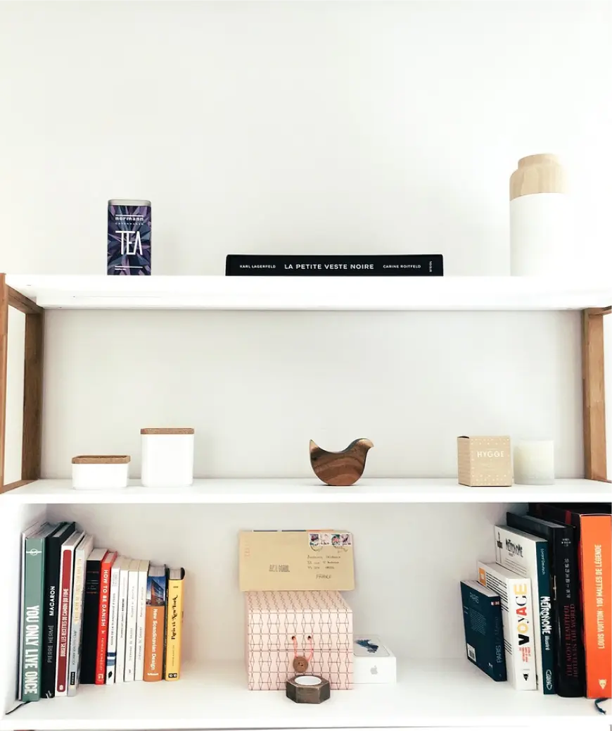 Minimalist bookshelf with various items. Services: customer experience services including optimization, journey mapping, and digital experience design.